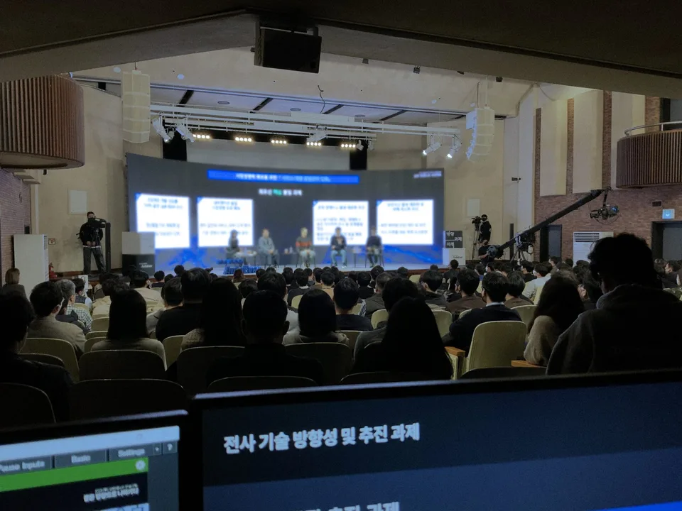 대강당 무대의 패널 토크를 카메라 여러 대와 지미집으로 중계하는 현장