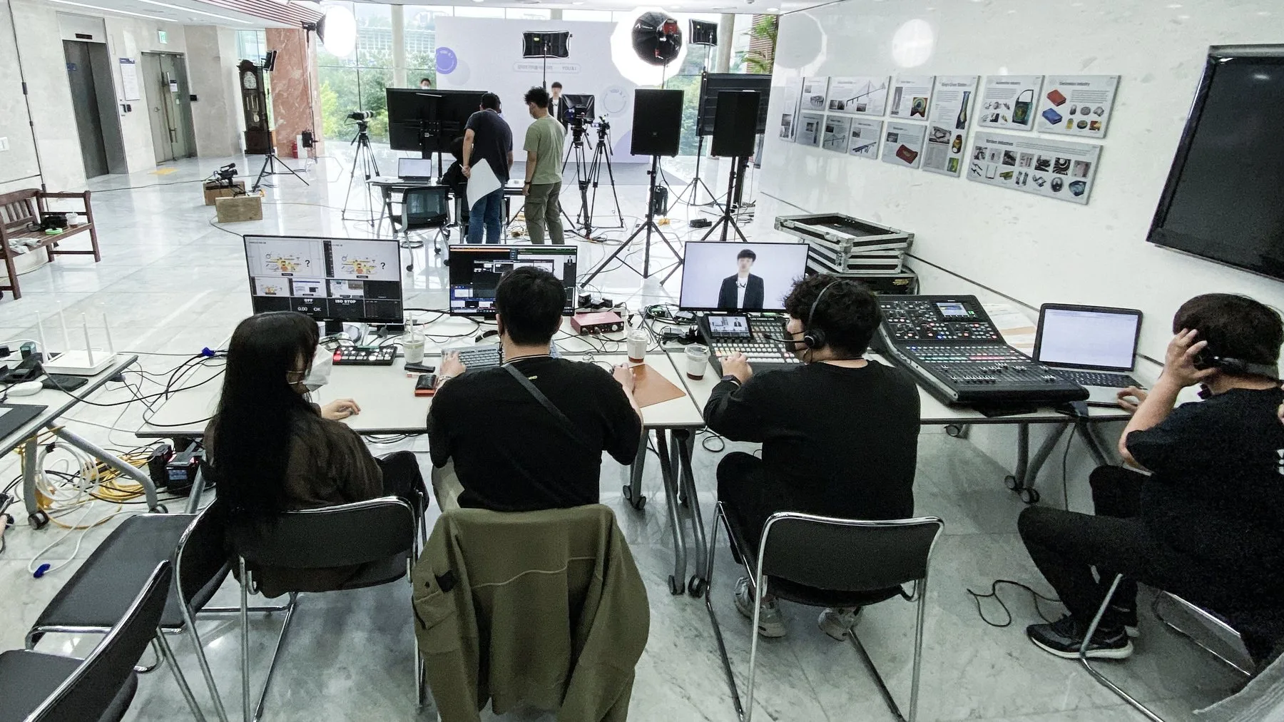 로비에 차린 중계석에서 스위처와 음향 콘솔로 강연을 송출하는 제작진